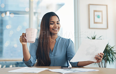 Buy stock photo Shot of a young businesswoman drinking coffee while working in an office