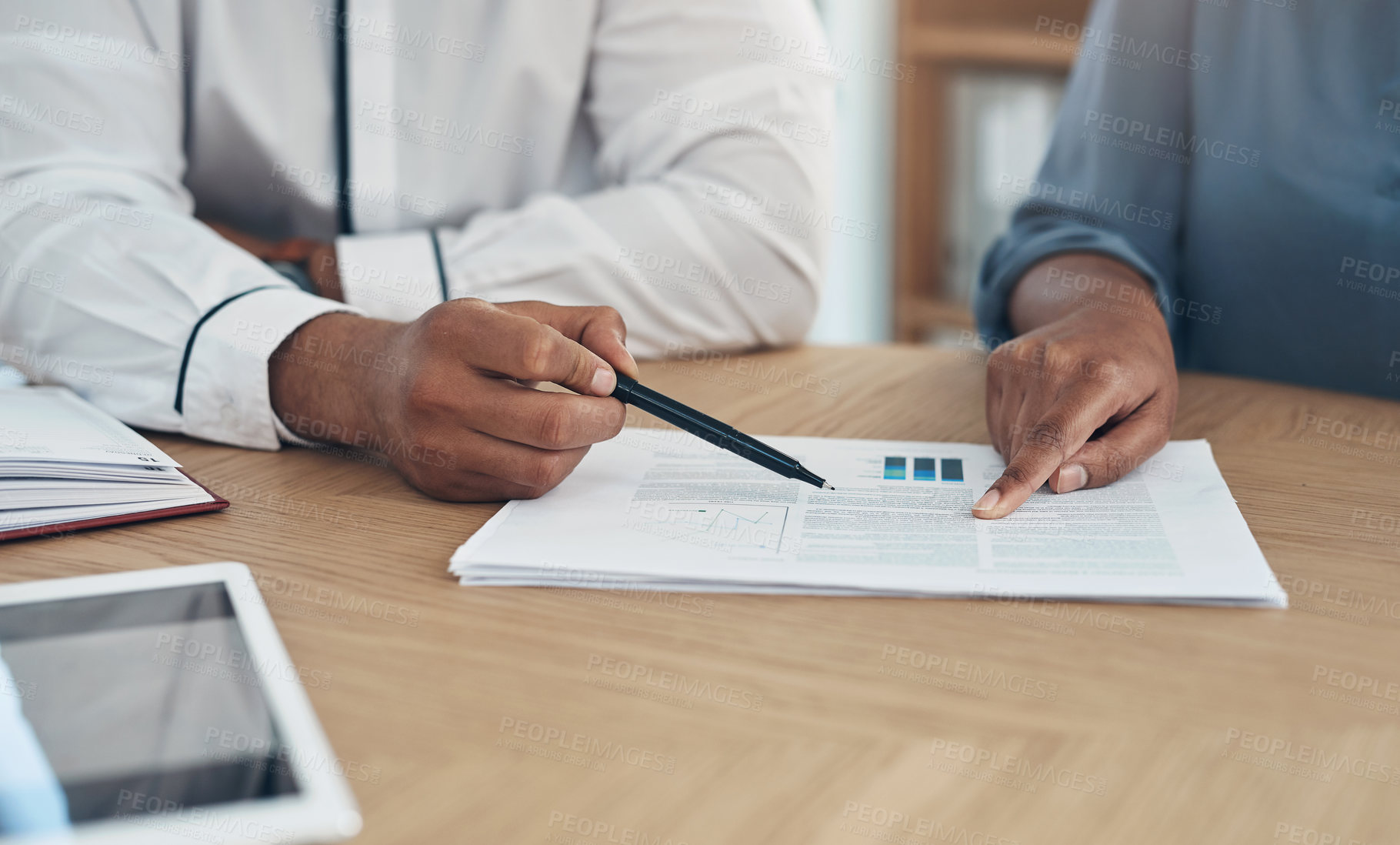 Buy stock photo Closeup shot of two businesspeople going through paperwork together in an office