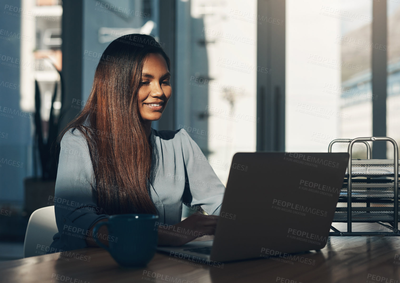 Buy stock photo Shot of a young businesswoman using a laptop in an office