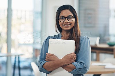 Buy stock photo Portrait of a young businesswoman holding a laptop while standing in an office