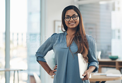 Buy stock photo Portrait of a young businesswoman holding a laptop while standing in an office