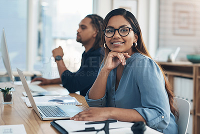 Buy stock photo Portrait of a young businesswoman working in an office with her colleague in the background