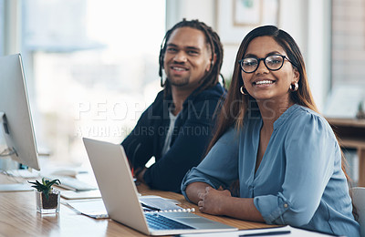 Buy stock photo Portrait of two businesspeople working alongside each other in an office