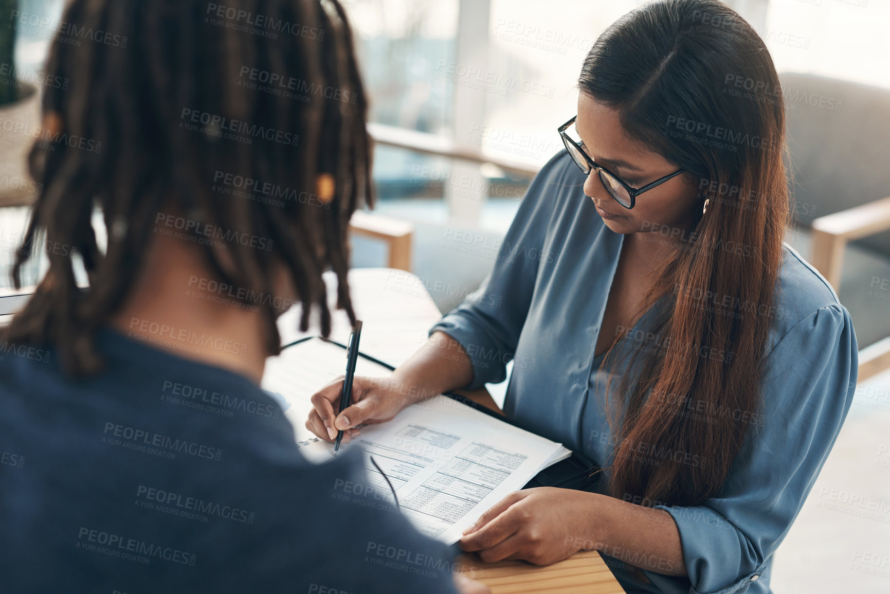 Buy stock photo Shot of two businesspeople going through paperwork together in an office