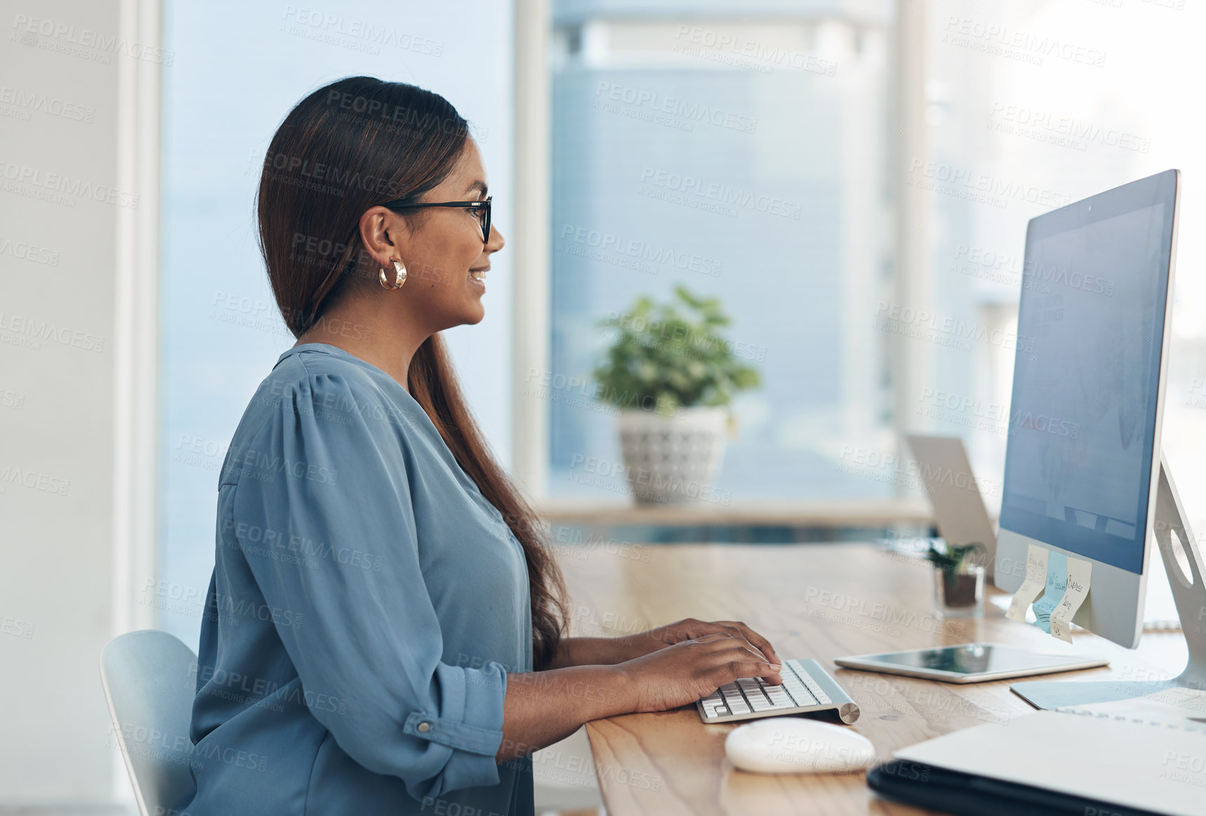 Buy stock photo Shot of a young businesswoman working on a computer in an office