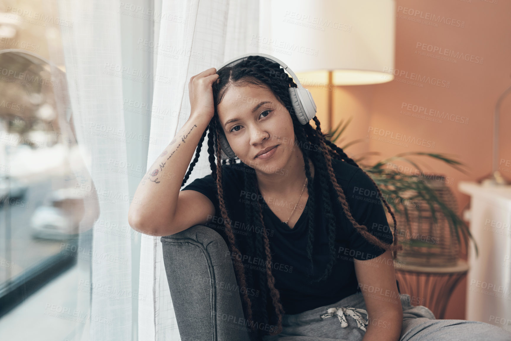 Buy stock photo Portrait of a young woman using headphones at home