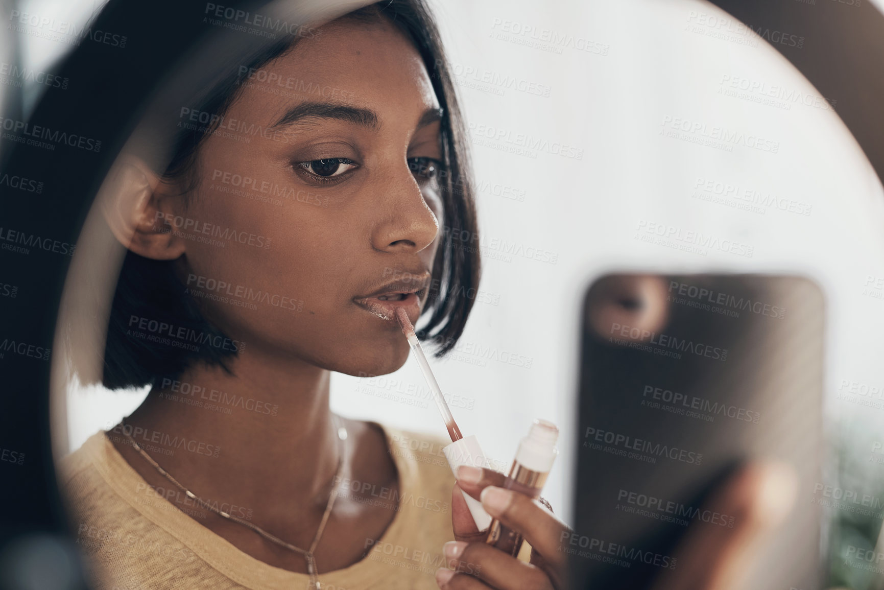 Buy stock photo Shot of a young woman applying makeup while filming a beauty tutorial at home