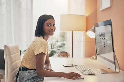 Buy stock photo Portrait of a young woman using a computer while working from home