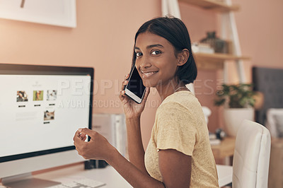 Buy stock photo Portrait of a young woman using a computer and smartphone while working from home