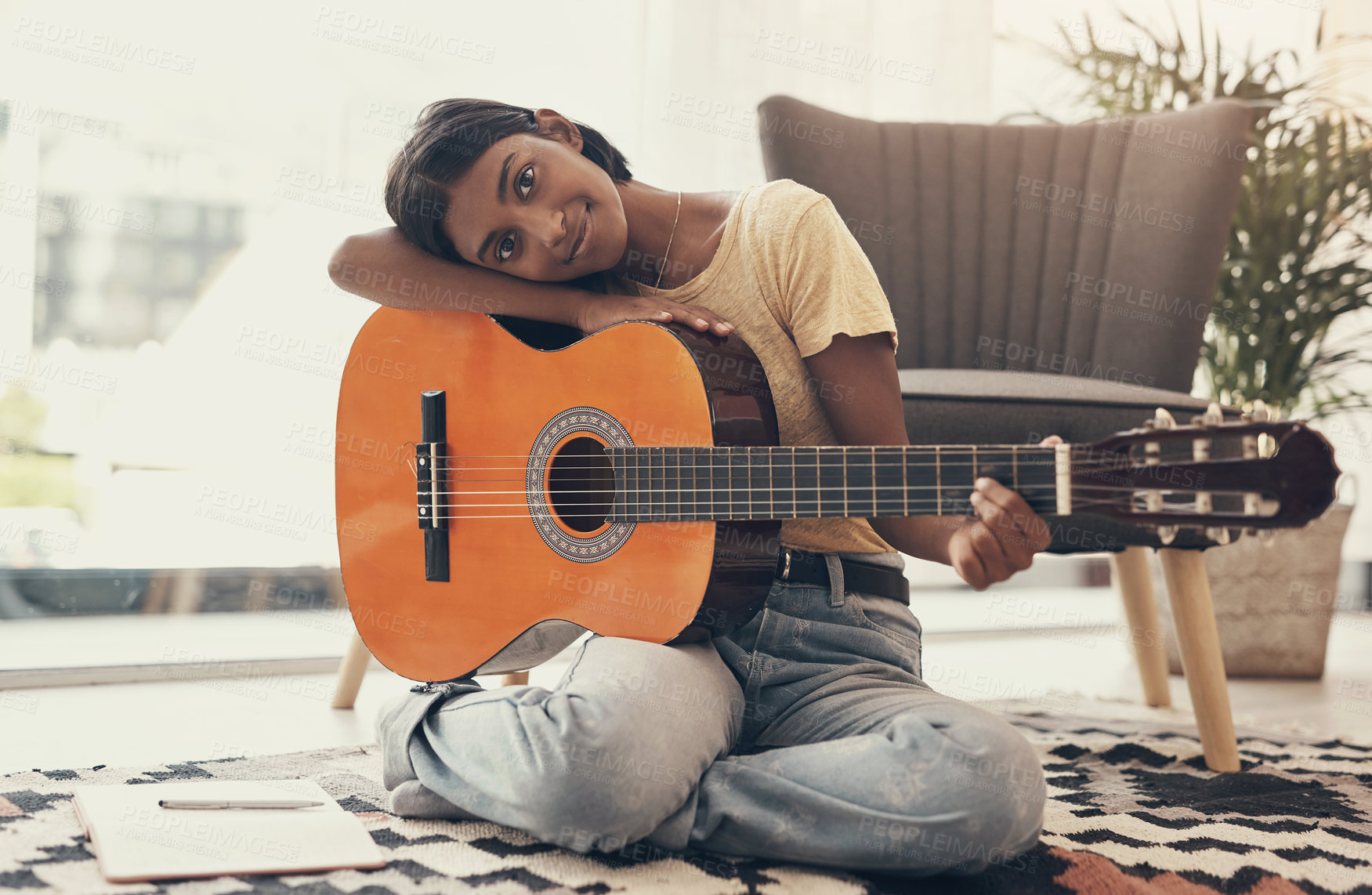 Buy stock photo Portrait of a young woman playing the guitar at home