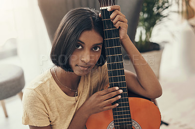 Buy stock photo Portrait of a young woman playing the guitar at home