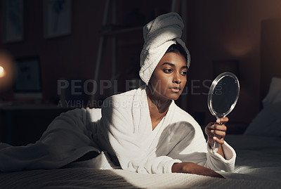 Buy stock photo Shot of a young woman looking at herself in the mirror while going through her beauty routine at home