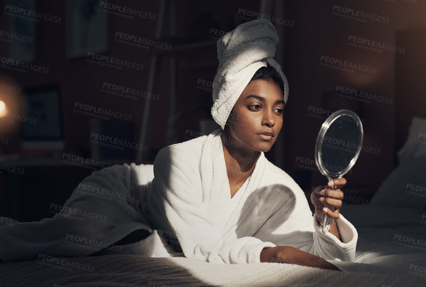 Buy stock photo Shot of a young woman looking at herself in the mirror while going through her beauty routine at home