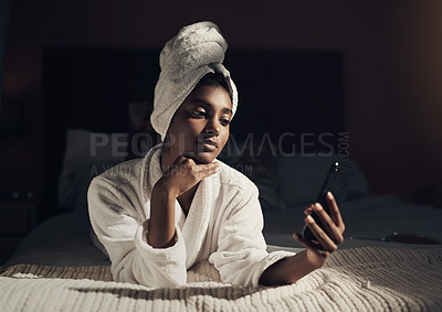 Buy stock photo Shot of a young woman using a smartphone while going through her beauty routine at home