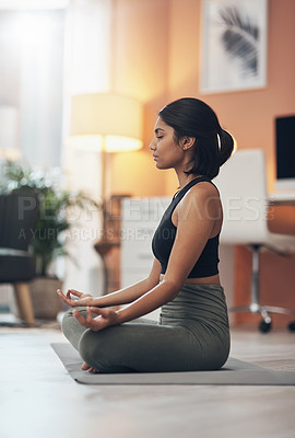 Buy stock photo Shot of a beautiful young woman meditating at home