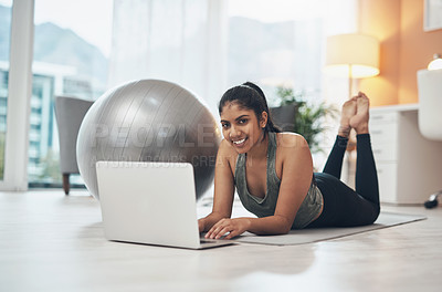 Buy stock photo Shot of a woman using her laptop while exercising at home