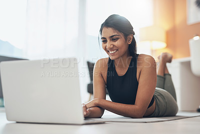 Buy stock photo Shot of a woman using her laptop while exercising at home