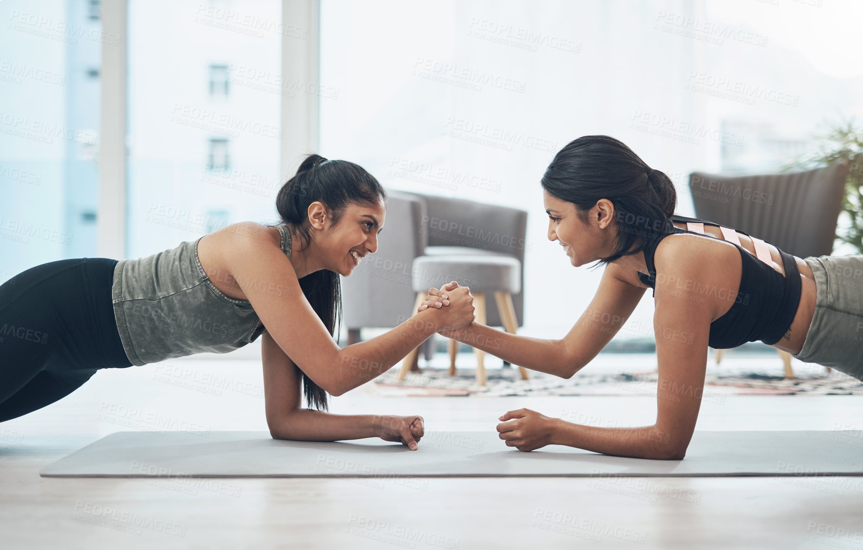 Buy stock photo Shot of two beautiful young women exercising together at home