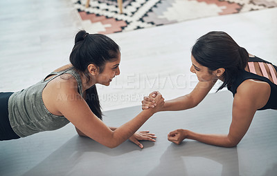 Buy stock photo Shot of two beautiful young women exercising together at home