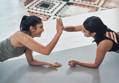 Buy stock photo Shot of two beautiful young women exercising together at home