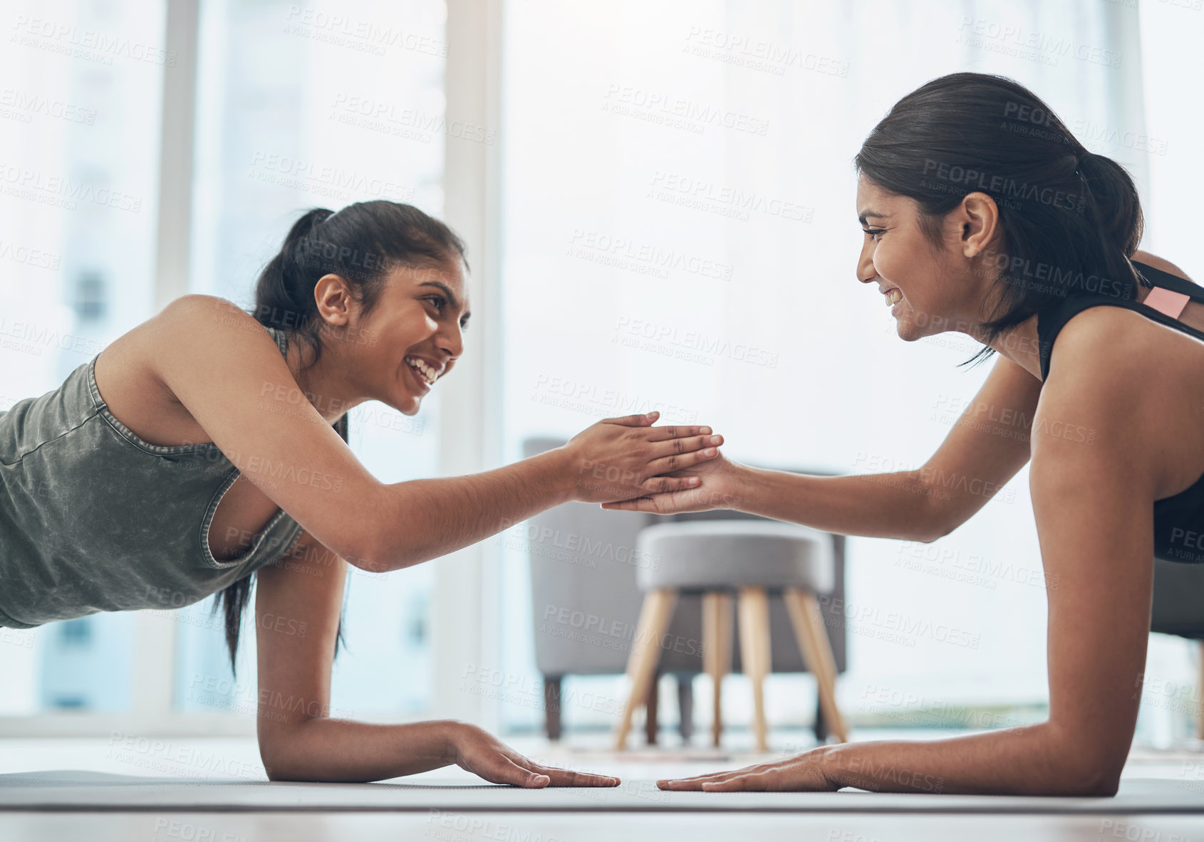 Buy stock photo Shot of two beautiful young women exercising together at home