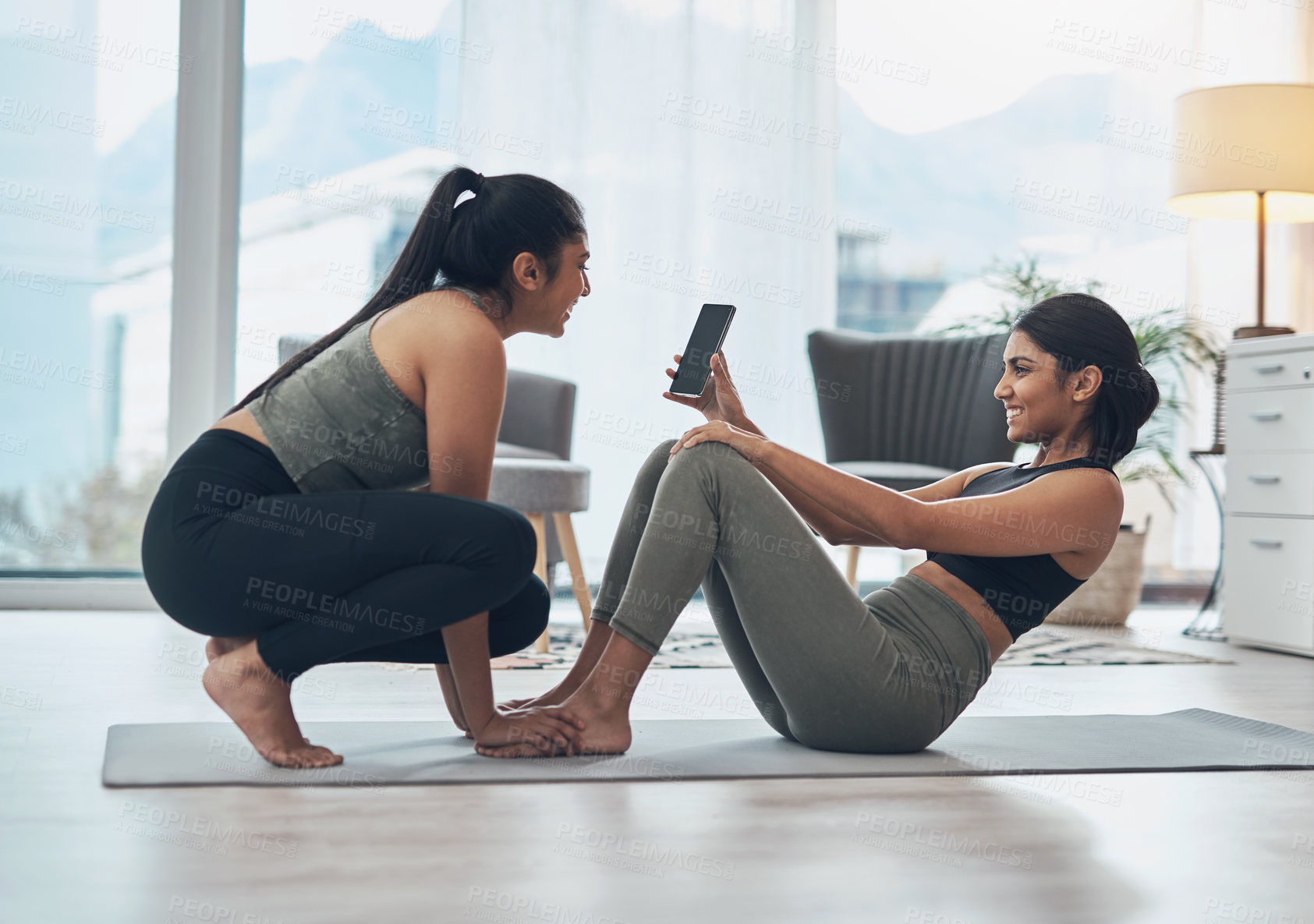 Buy stock photo Shot of two beautiful young women exercising together at home