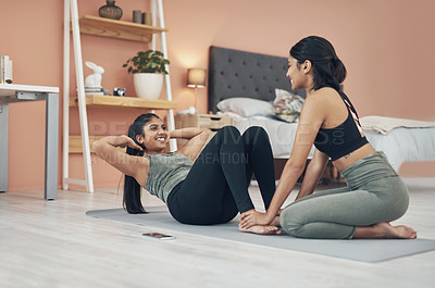 Buy stock photo Shot of two beautiful young women exercising together at home