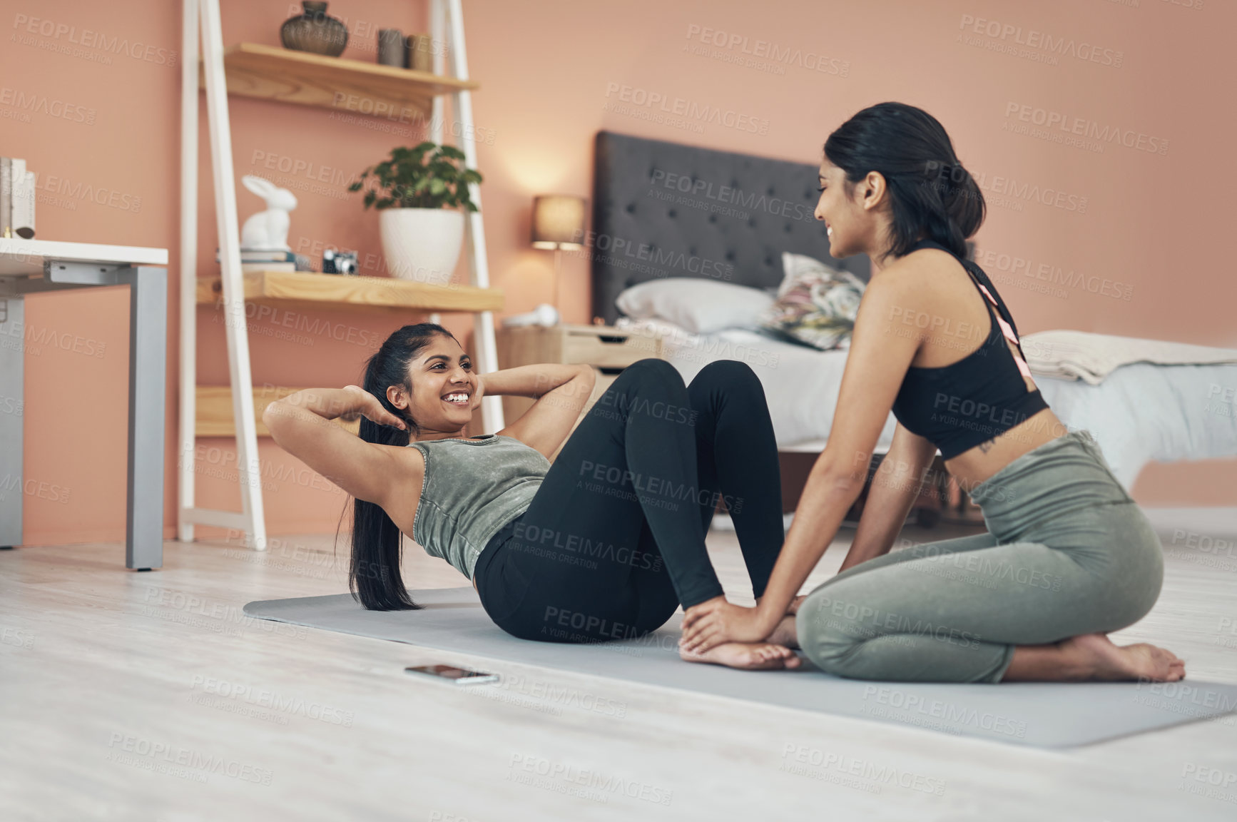 Buy stock photo Shot of two beautiful young women exercising together at home