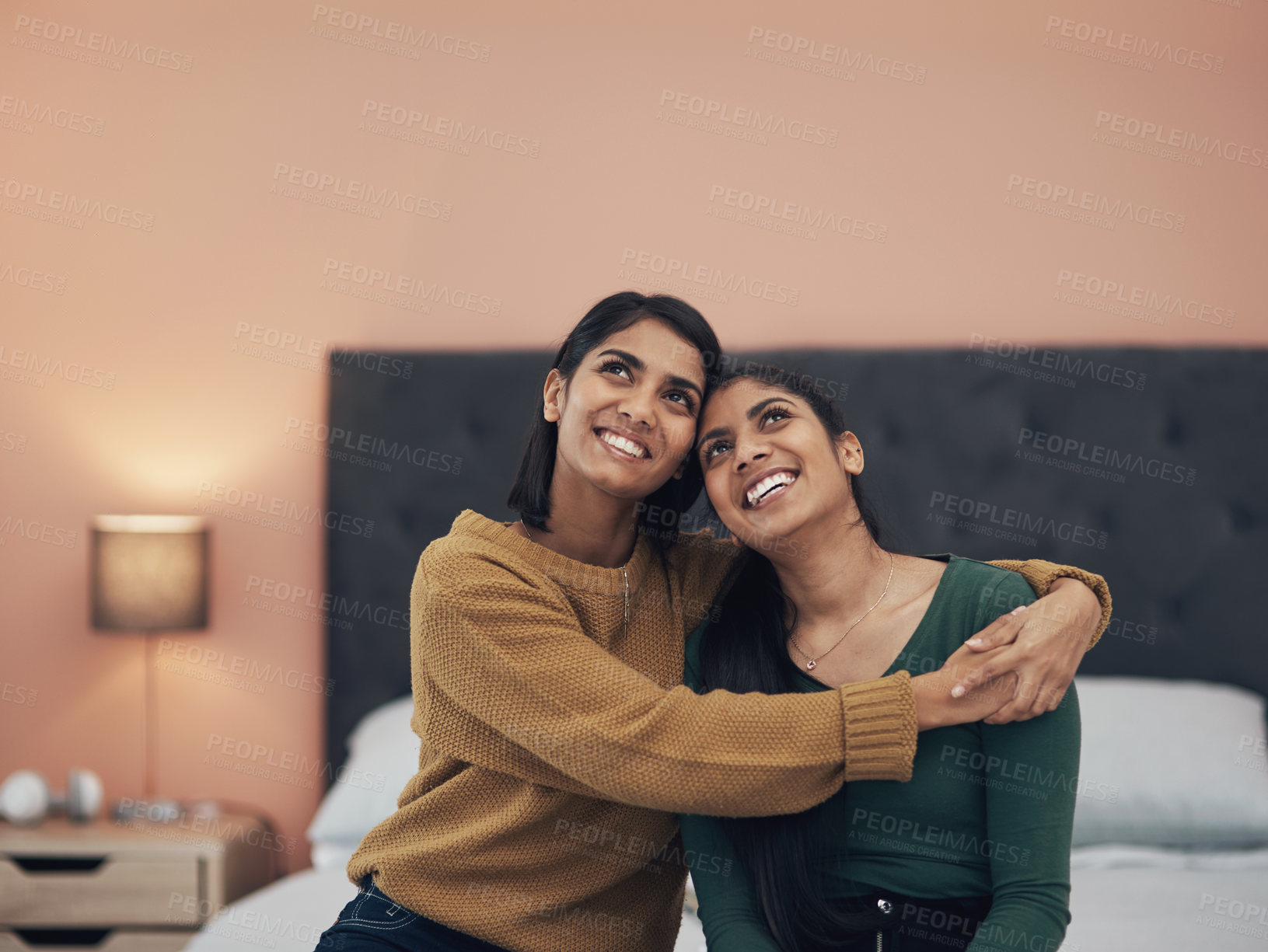 Buy stock photo Shot of two happy young women sitting together at home