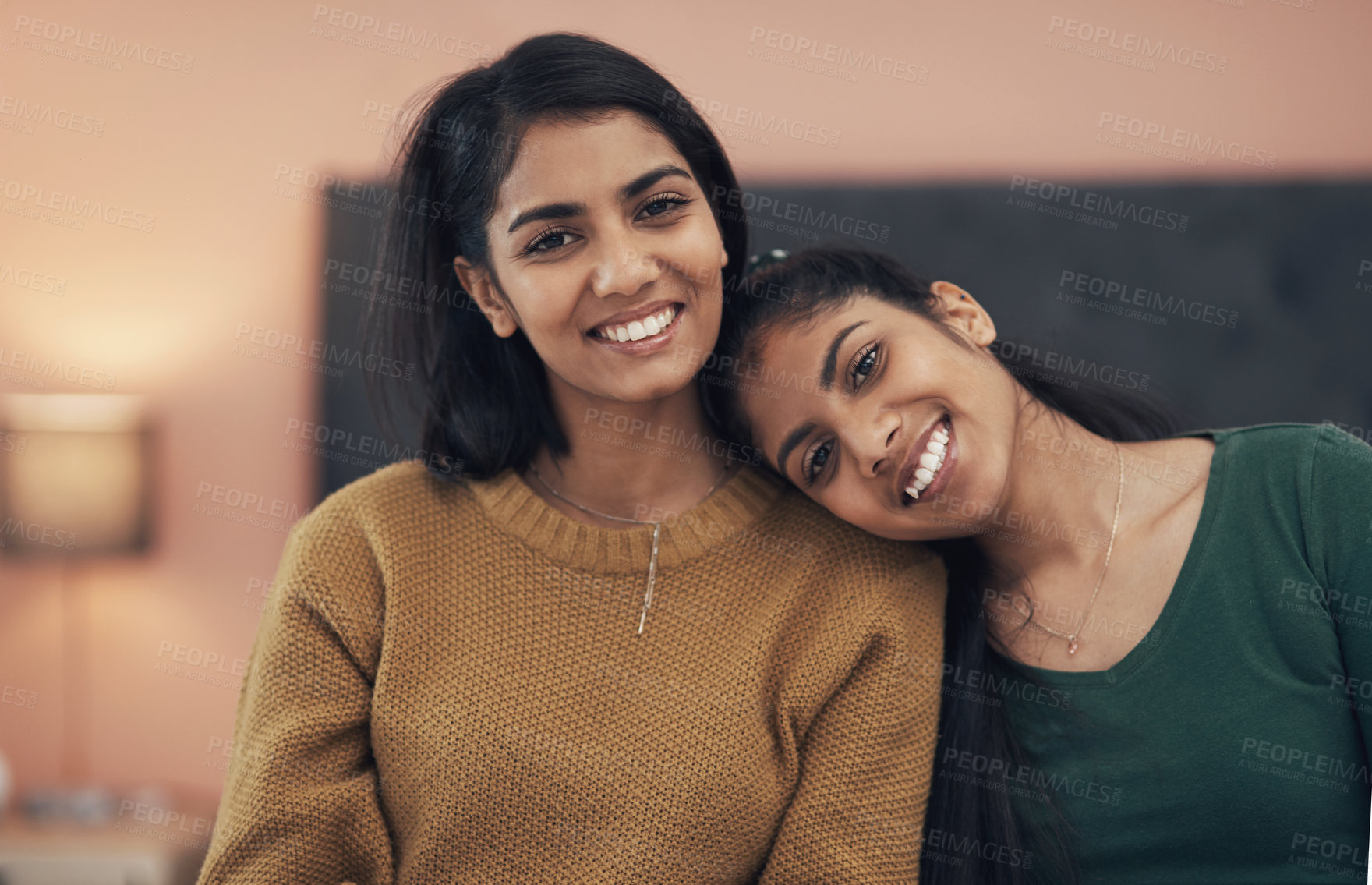 Buy stock photo Shot of two happy young women sitting together at home