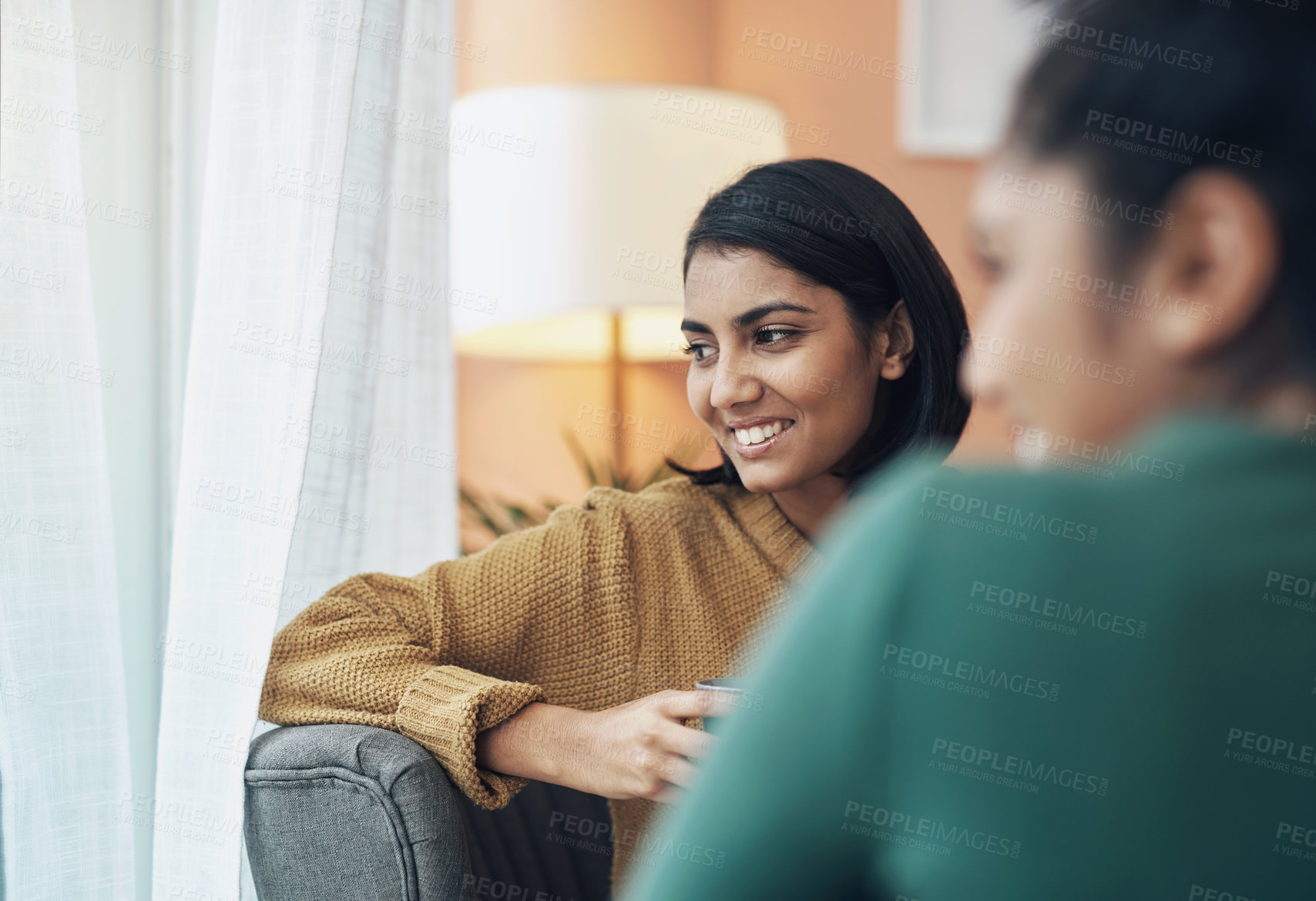 Buy stock photo Cropped shot of two young women sitting together at home
