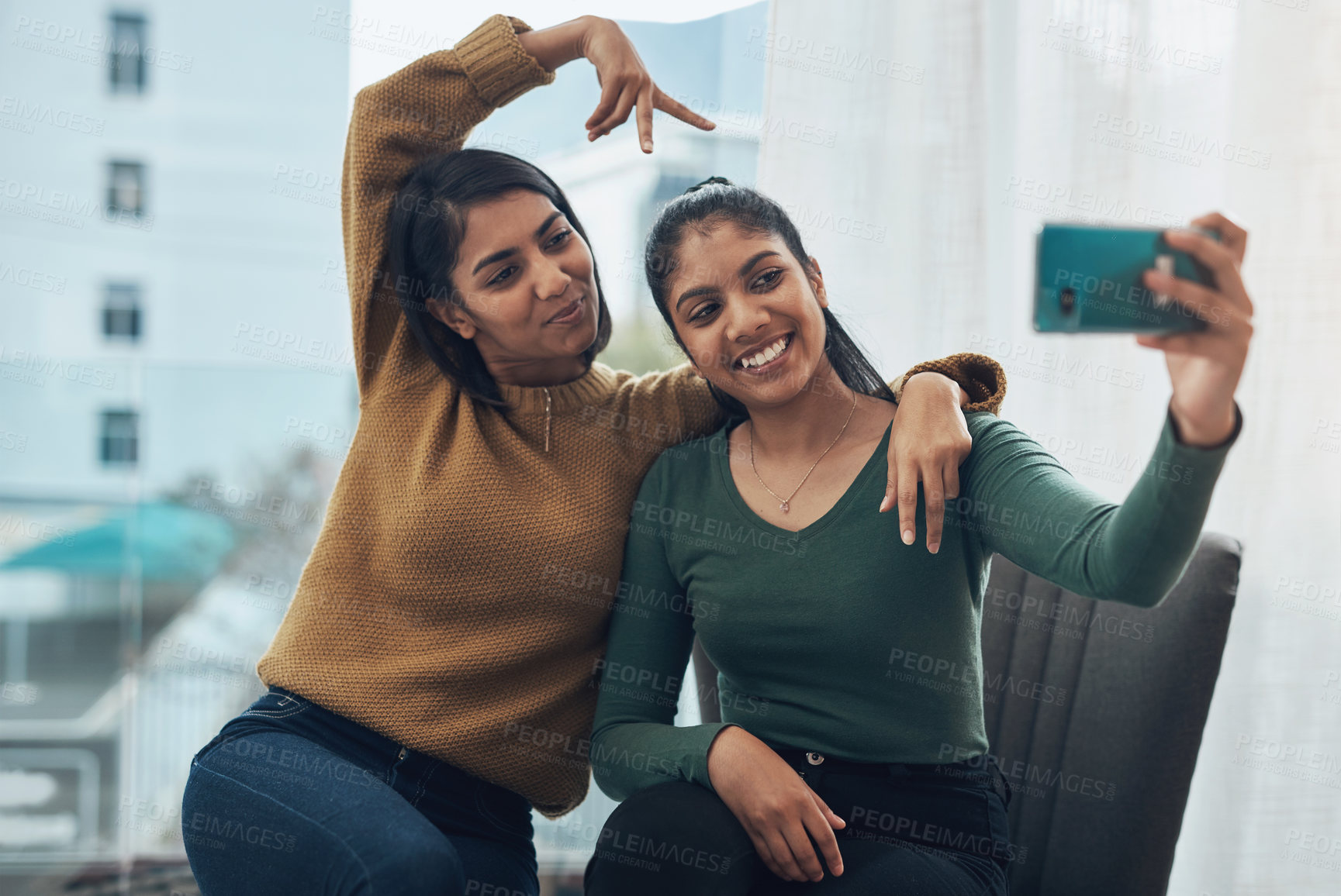 Buy stock photo Peace sign, selfie and smile with sisters in living room of home together for bonding, love or memories. App, hand gesture or profile picture with girl siblings in city apartment for photograph