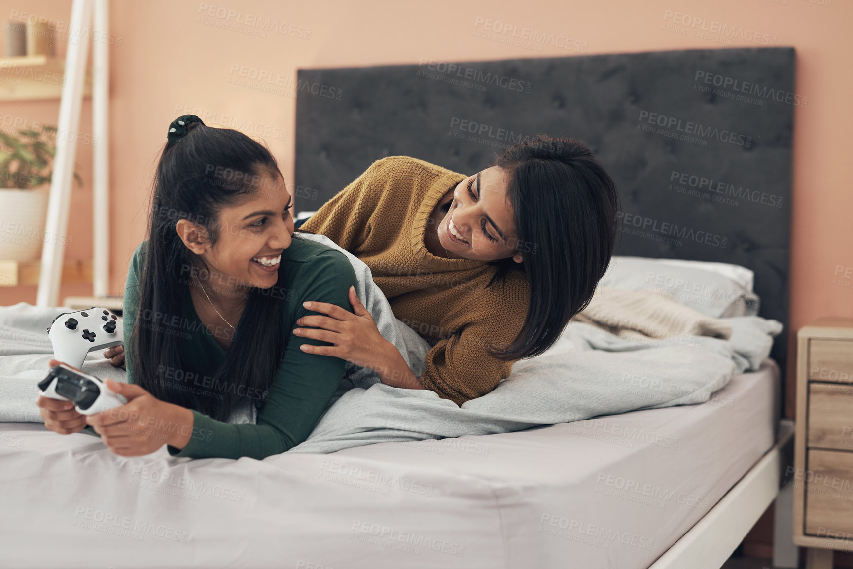 Buy stock photo Shot of two young women playing video games at home