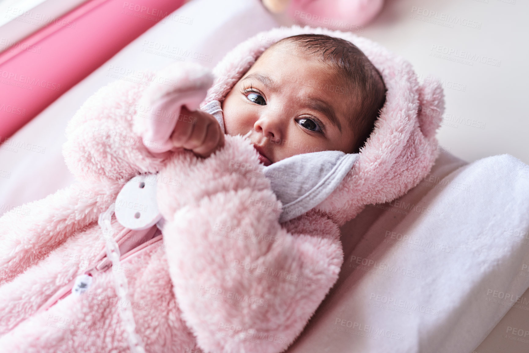 Buy stock photo Shot of an adorable baby girl on a diaper changing station at home