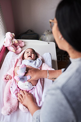 Buy stock photo Shot of a woman changing her baby girl’s diaper at home