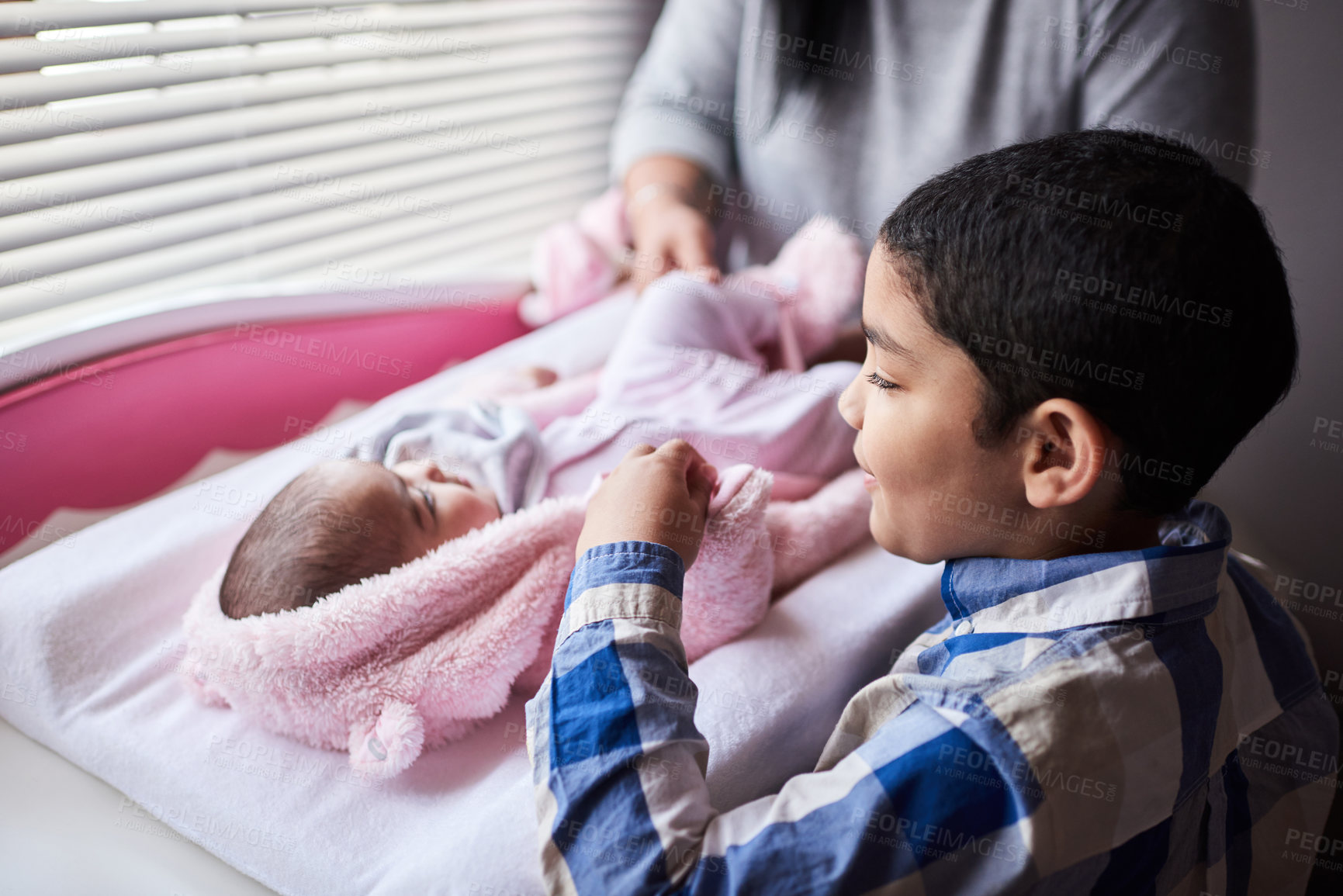 Buy stock photo Shot of an adorable little boy bonding with his newborn sister in the bedroom at home