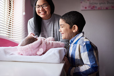Buy stock photo Shot of an adorable little boy bonding with his newborn sister in the bedroom at home