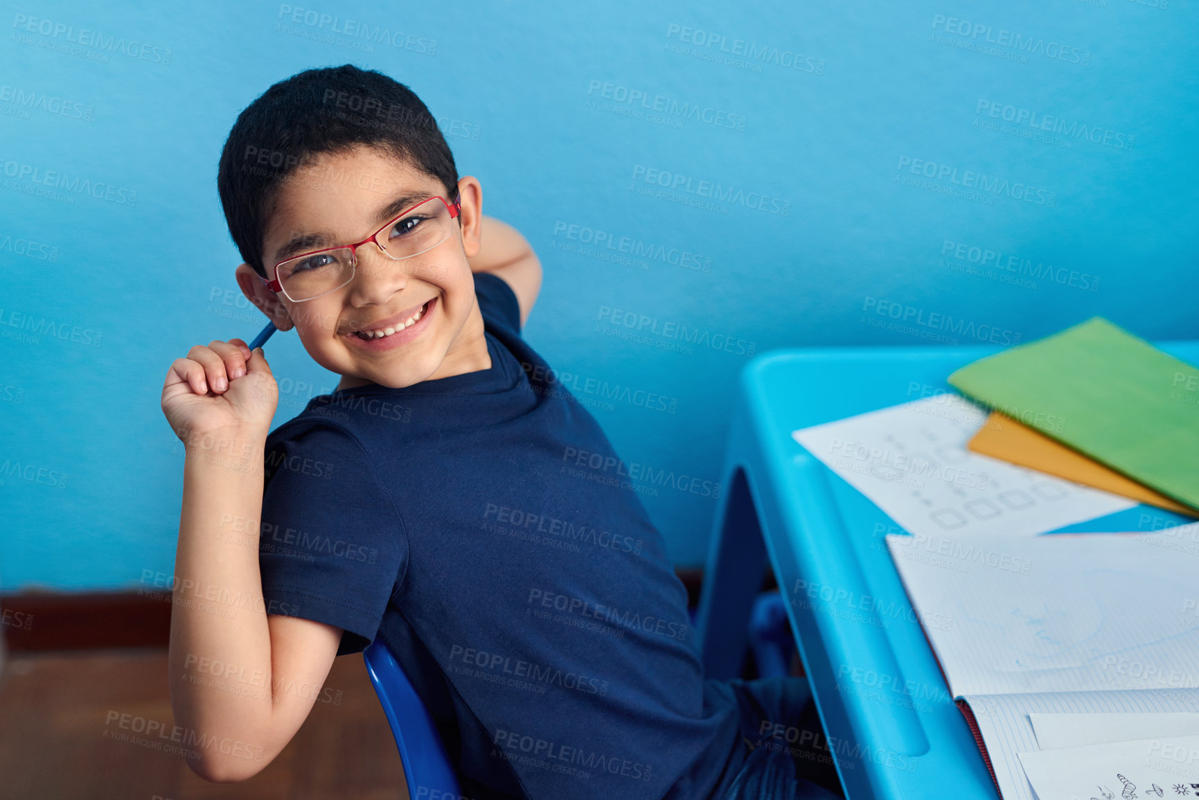 Buy stock photo Shot of an adorable little boy completing a school assignment at his desk