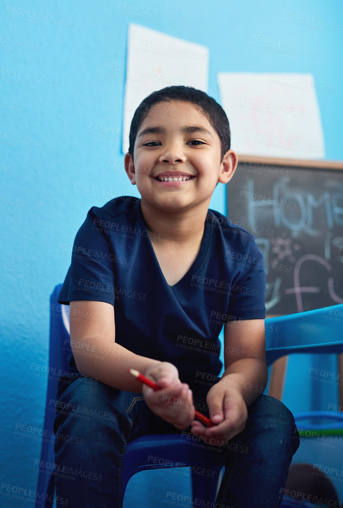 Buy stock photo Shot of an adorable little boy completing a school assignment at his desk