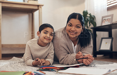 Buy stock photo Shot of an adorable little boy completing a school assignment with his mother at home