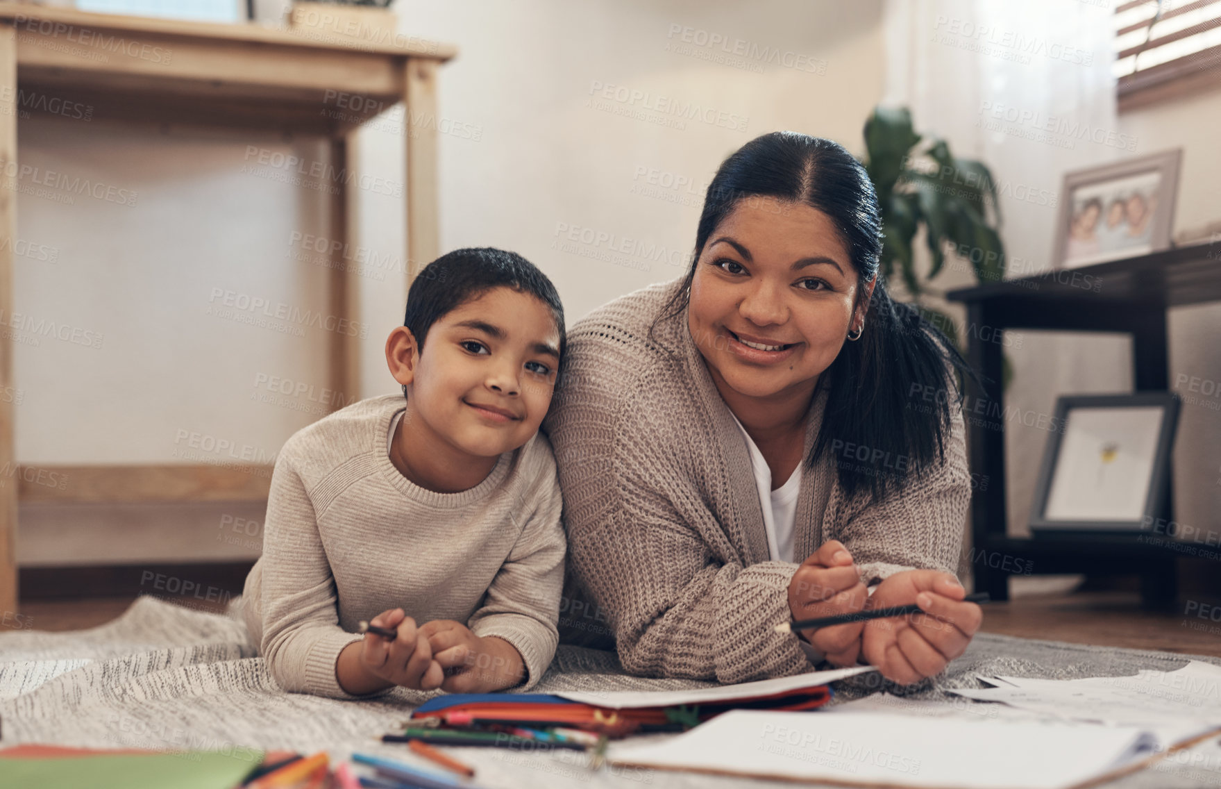 Buy stock photo Shot of an adorable little boy completing a school assignment with his mother at home