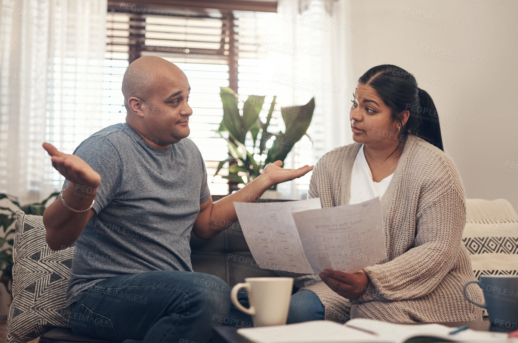 Buy stock photo Shot of a young couple having an argument while going over paperwork at home