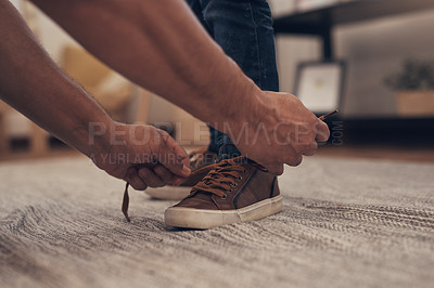 Buy stock photo Shot of an unrecognisable little boy getting his shoelaces tied by his father at home