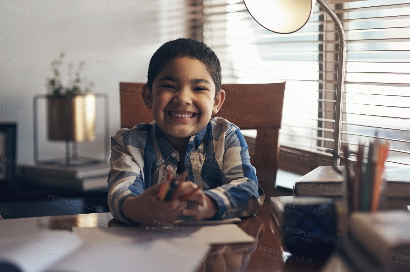 Buy stock photo Shot of an adorable little boy completing a school assignment at home