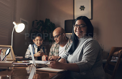 Buy stock photo Shot of a young woman using a laptop while her husband and son complete a school assignment together