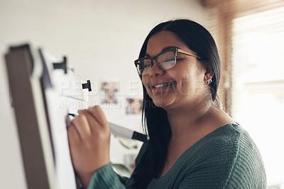 Buy stock photo Shot of a young woman using a whiteboard to teach a lesson from home