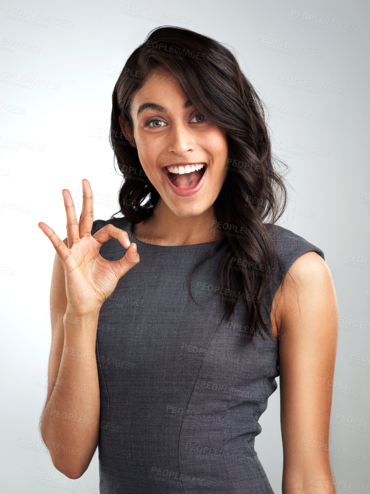 Buy stock photo Cropped shot of a beautiful young woman posing against a grey background