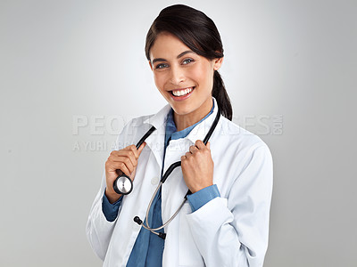 Buy stock photo Studio portrait of a confident young doctor posing against a grey background
