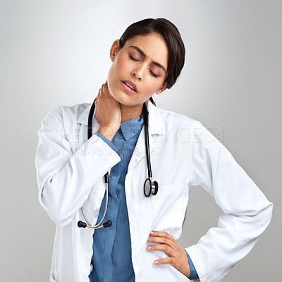 Buy stock photo Studio shot of a young doctor experiencing neck pain against a grey background