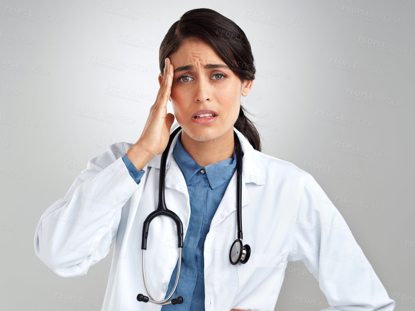 Buy stock photo Studio shot of a young doctor experiencing stress against a grey background